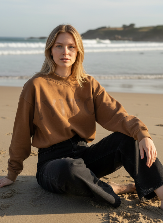 Magasin Dawo IYITO Sweater Ines in Kokosbraun aus 100% Baumwolle, getragen von einer Frau am Strand